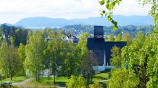 Holmen kirke i frodig sommerlandskap. Fotograf: Norunn Edvardsen