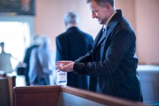 Fra dåp i Fenstad kirke i koronatiden, håndsprit står utplassert i kirkebenken. Foto: Bo Mathisen.