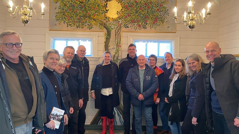 Foran Simonetta Saengers «Livets tre» i Holmsbu kapell: Fra venstre lokal kulturformidler Frank Tangen, Rådgiver kulturliv Asker kommune Gro Jerpåsen, leder av kirkens venneforening Eva Myhrene, fellesrådets rådgiver kirkebygg Reidar Haugo, venneforeningens kasserer Bjørn Bakken, prosjektleder Linda Lyngstad Marthinsen, daglig leder Asker kulturråd Erik de Mora, fylkesordfører Roger Ryberg, menighetsrådets utstillingsansvarlig Tiril Bjørkvold, avdelingssjef Jon Endre Røed Olsen, avdelingsleder Hilde Nygaard i Asker kommunes kulturavdeling, Kunstfaglig rådgiver i Asker kommune Vibeke Hermanrud, turistsjef i Asker Ann Kristin Hagby og kirkesjef John Grimsby. Foto: Hege M. Andersen/Søndre Hurum menighetsråd.