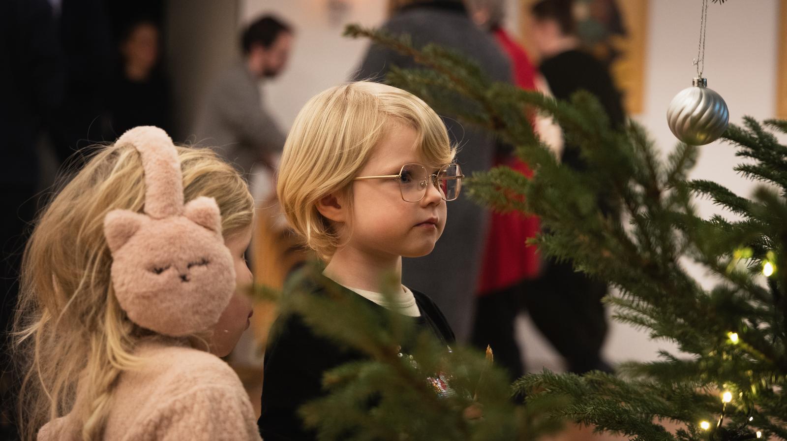 Foto: Hans Jakob Heimvoll. Bilde av to barn som ser på et pyntet juletre.