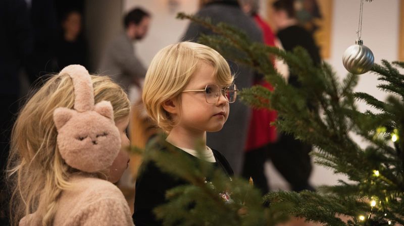Foto: Hans Jakob Heimvoll. Bilde av to barn som ser på et pyntet juletre.