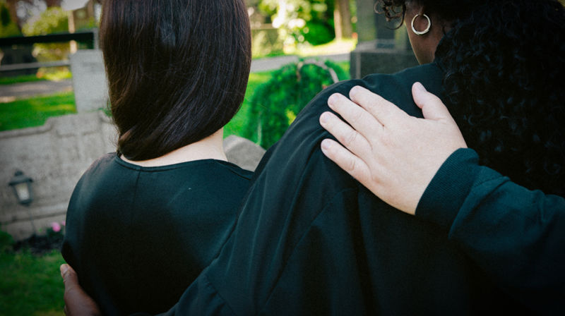 Personer som holder rundt hverandre i en begravelse. Foto: Jonathan Vivaas Kise.