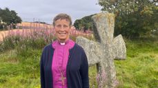 Biskop Anne Lise Ådnøy ved steinkorsene på Tjora, et talende vitnesbyrd om tidlig kristen påvirkning.