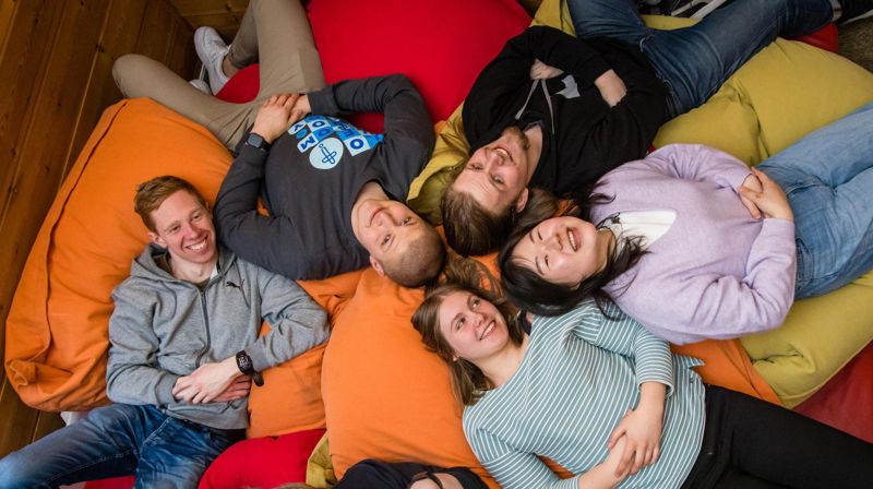 Foto: Den norske kirke / Marius Vervik. Smilende ungdommer som ligger på sakkosekker.