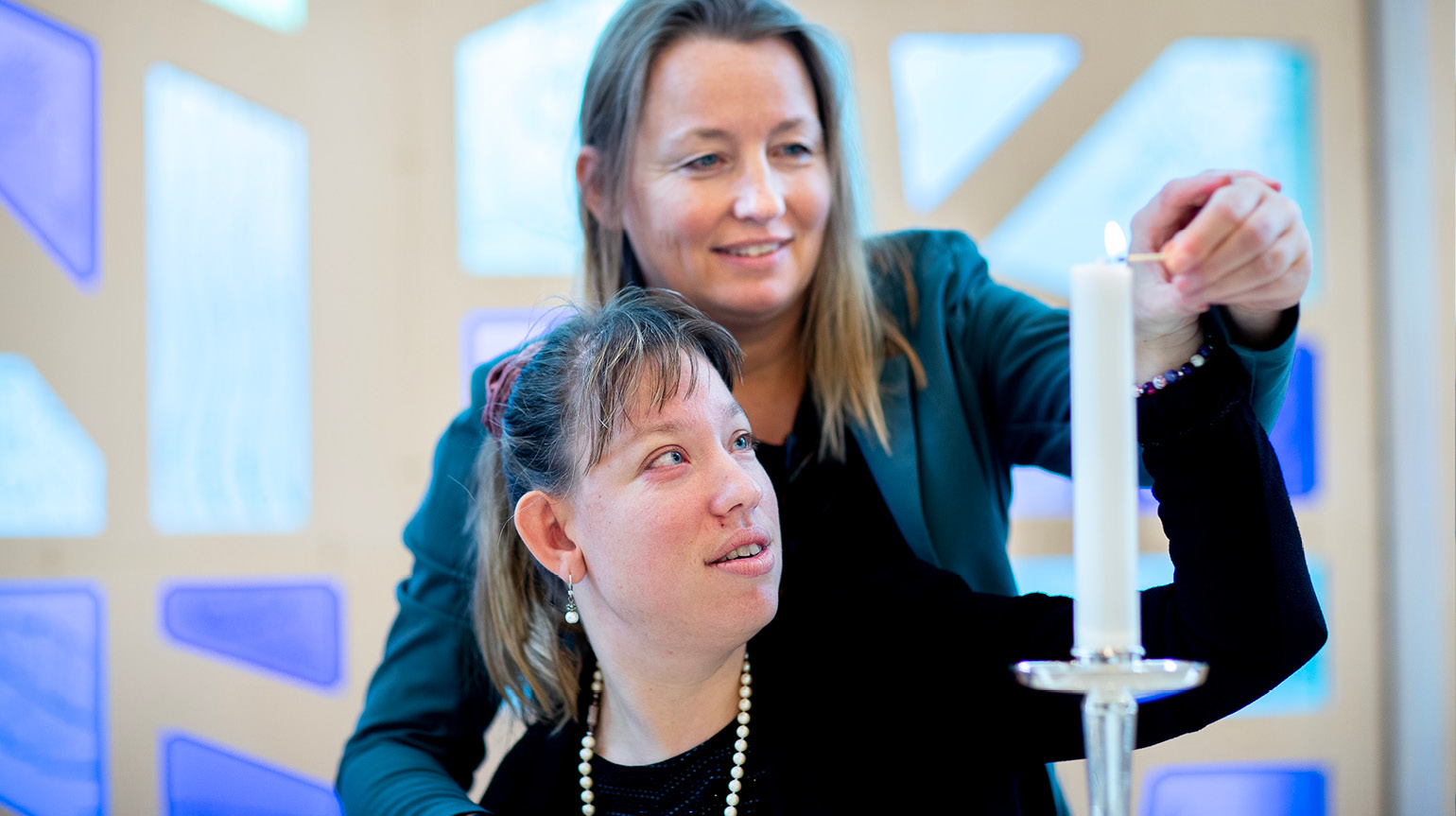 Kvinne med ledsager tenner lys i kirken