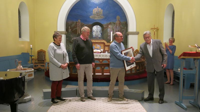 Oscar J. Garnes deler ut diakoniprisen i Kviteseid kyrkje til Astrid og Jan Gunnar Breivik (t.v.) og Håkon Birkeland.