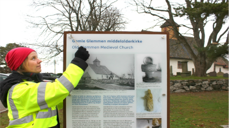 Arkeolog Jone Kile-Vesik monterer nytt informasjonsskilt ved Gamle Glemmen kirke i Fredrikstad, foto: Silje Haugsten Ellefsen