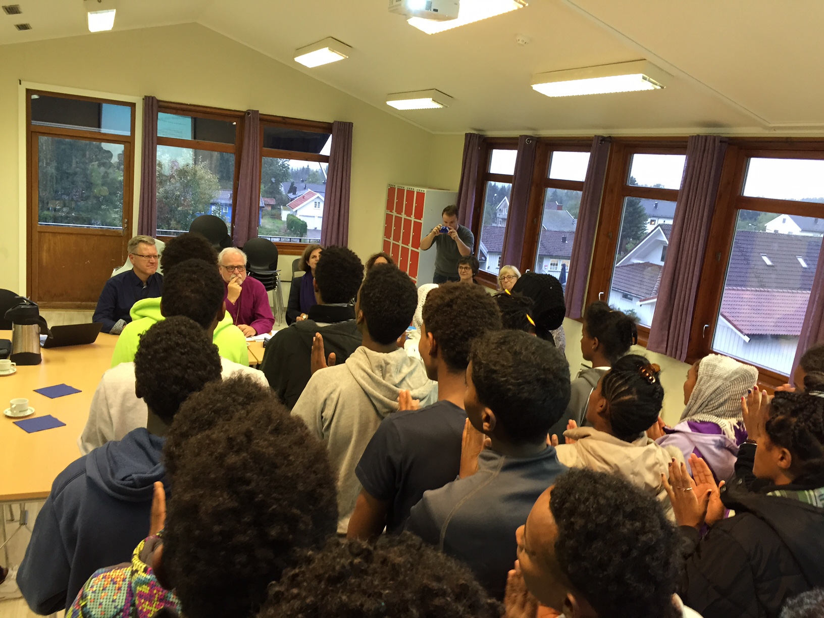 Eritreiske mindreårige asylsøkere synger for biskopen og ordfører Erik Unaas. På grunn av personvernhensyn er det ikke anledning til å vise ansiktene deres.