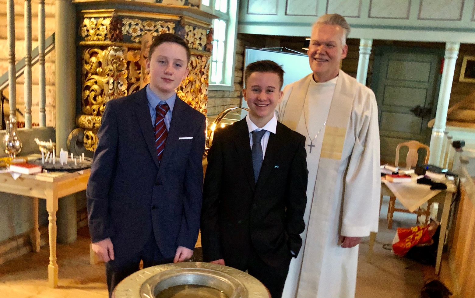 Tvillingane Jens og J&#248;rgen Lyngved har akkurat vorte d&#248;ypte av sokneprest K&#229;re Gloslie i Skj&#229;k. Foto: Jorun Vang