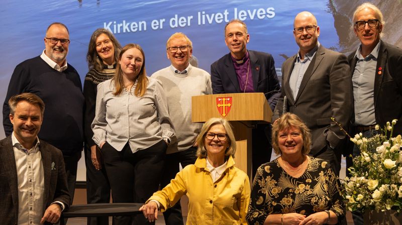 Hamar bispedømmeråd under Kirkemøtet 2026. Bak fv: Ole Jacob Dyrnes, Therese Wagle Bazard, Vanja Hole Joramo, Gunnstein Endal, Biskop Ole Kristian Bonden, Trond Enemo (vara for Adrian Sagvold Grøndahl), Sveinung Moesgaard Skjesol. Foran f.v: Stiftsdirektør Freddy Knutsen, Anne Kristine Rossebø, Bispedømmerådets leder Kjersti Drtina Øversveen. Forfall: Vidar Haugen. Foto: Heidi Olsen / Den norske kirke