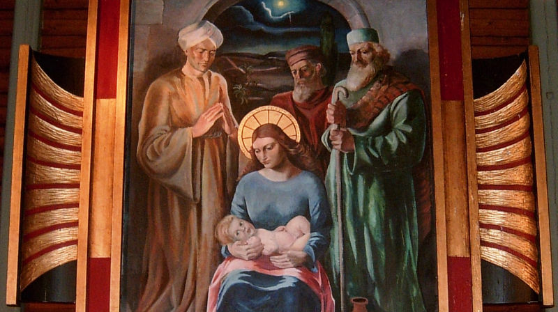 Utsnitt fra altertavla i Øvre Vang kirke. Altertavla er malt i 1933 av Ola Mathias Abrahamsson og forestiller kongenes tilbedelse av Jesusbarnet. Bildet er spesielt blant annet ved at bare Maria har stråleglans rundt hodet, men ikke Jesusbarnet. Det siste skyldes visstnok at kunstneren ble pålagt å gjøre om på bildet etter en klage.