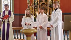 Laminta, Stian og Benjamin saman med prest Karl Johan Bjørge under dåpen i Vatne kyrkje.