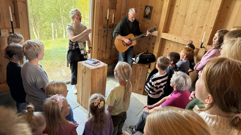 Biskop Herborg (midt i flokken) fikk eksklusiv konsert da hun møtte skolebarna fra Drivdalen oppvekstsenter i Mikaelskapellet (Foto: Aud Kristin Saltvik Aasen)