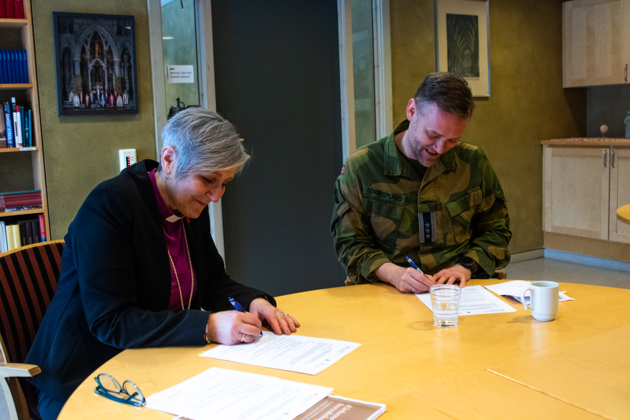 Biskop Herborg Finnset og oberst Ole Marius Tørrisplass signerer samarbeidsavtalen. Den første i sitt slag.