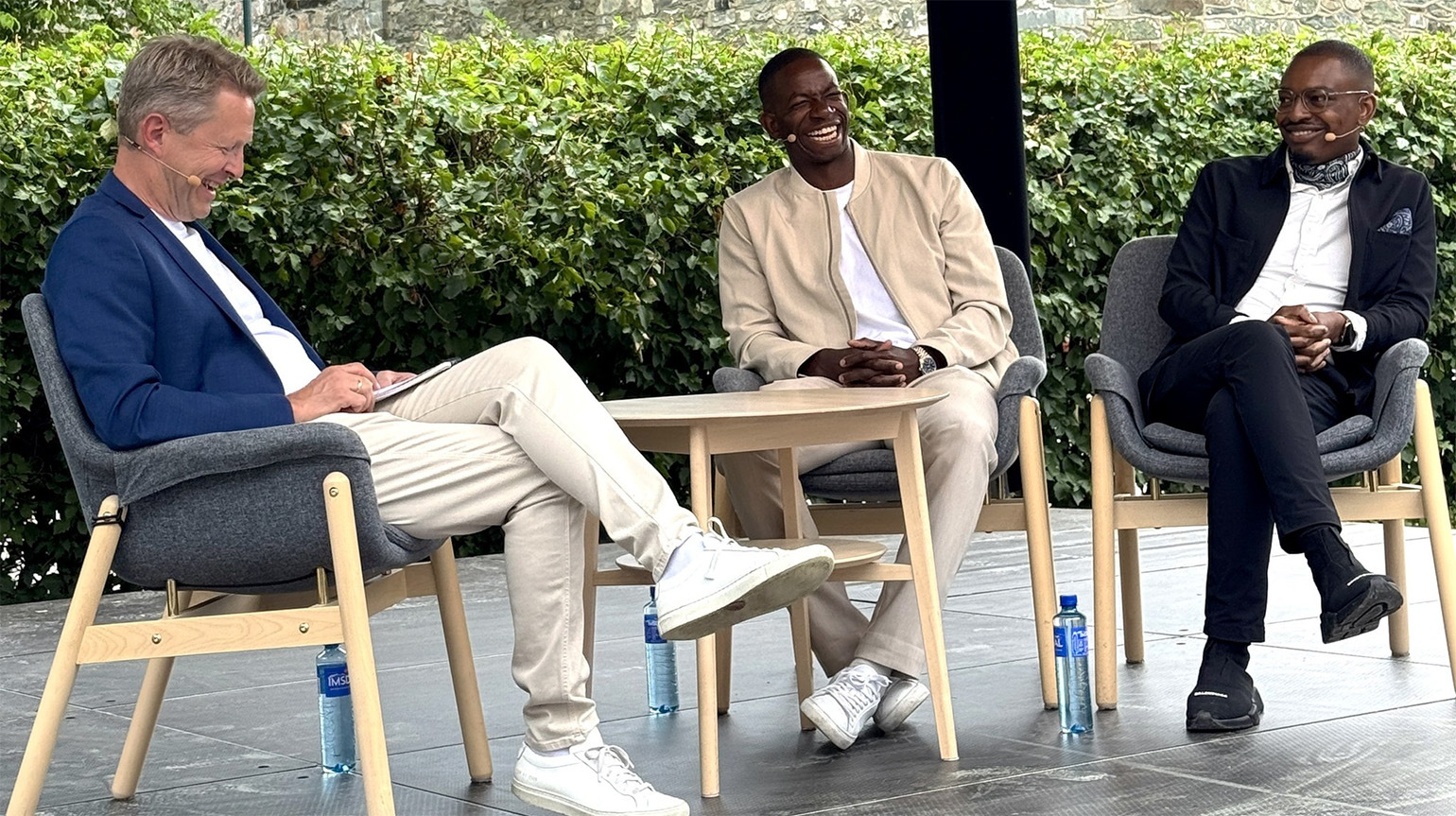 Programleder Magne Vik Ravndal (f.v), Mushaga Bakenga og Leon Bafondoko p&#229; scenen i Kirkehagen under Olavsfest.