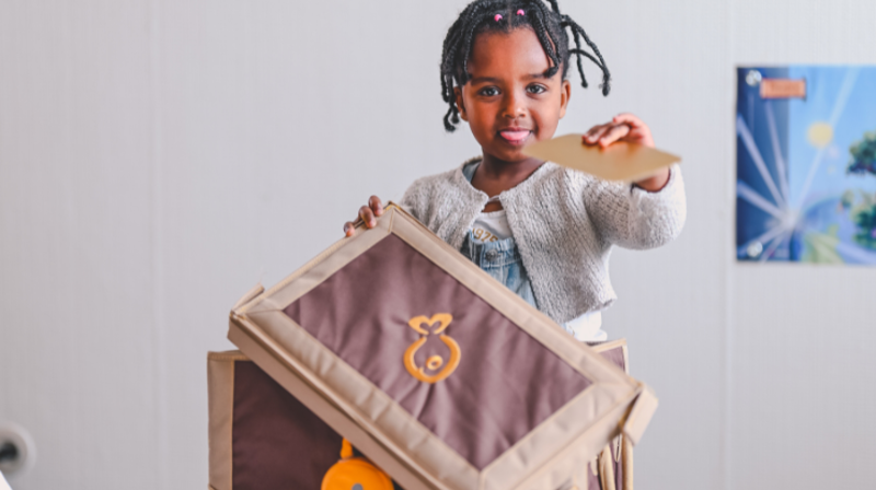 Jente som holder skattekista på søndagsskolen.