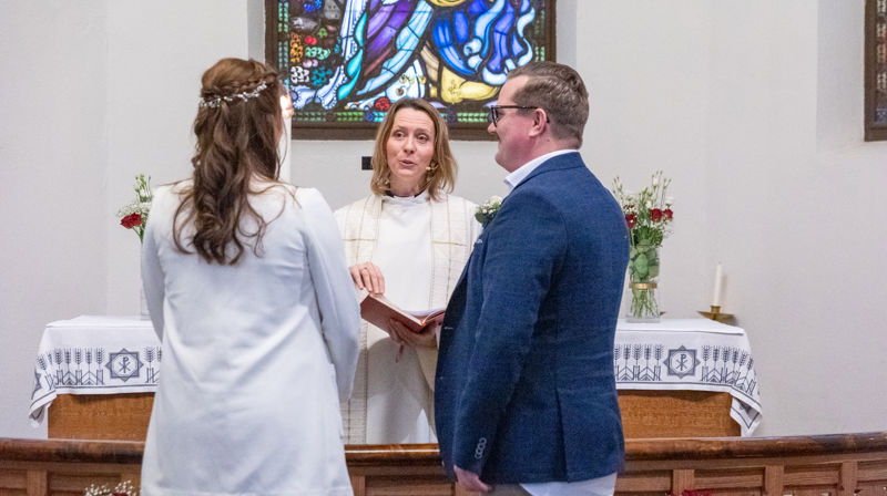 Synstolkning: Bjørg og Are giftet seg på drop-in i 2023. Her sammen med prost Kjerstin Jensen i Ås kirke. Foto: Inger Eide Nordseth