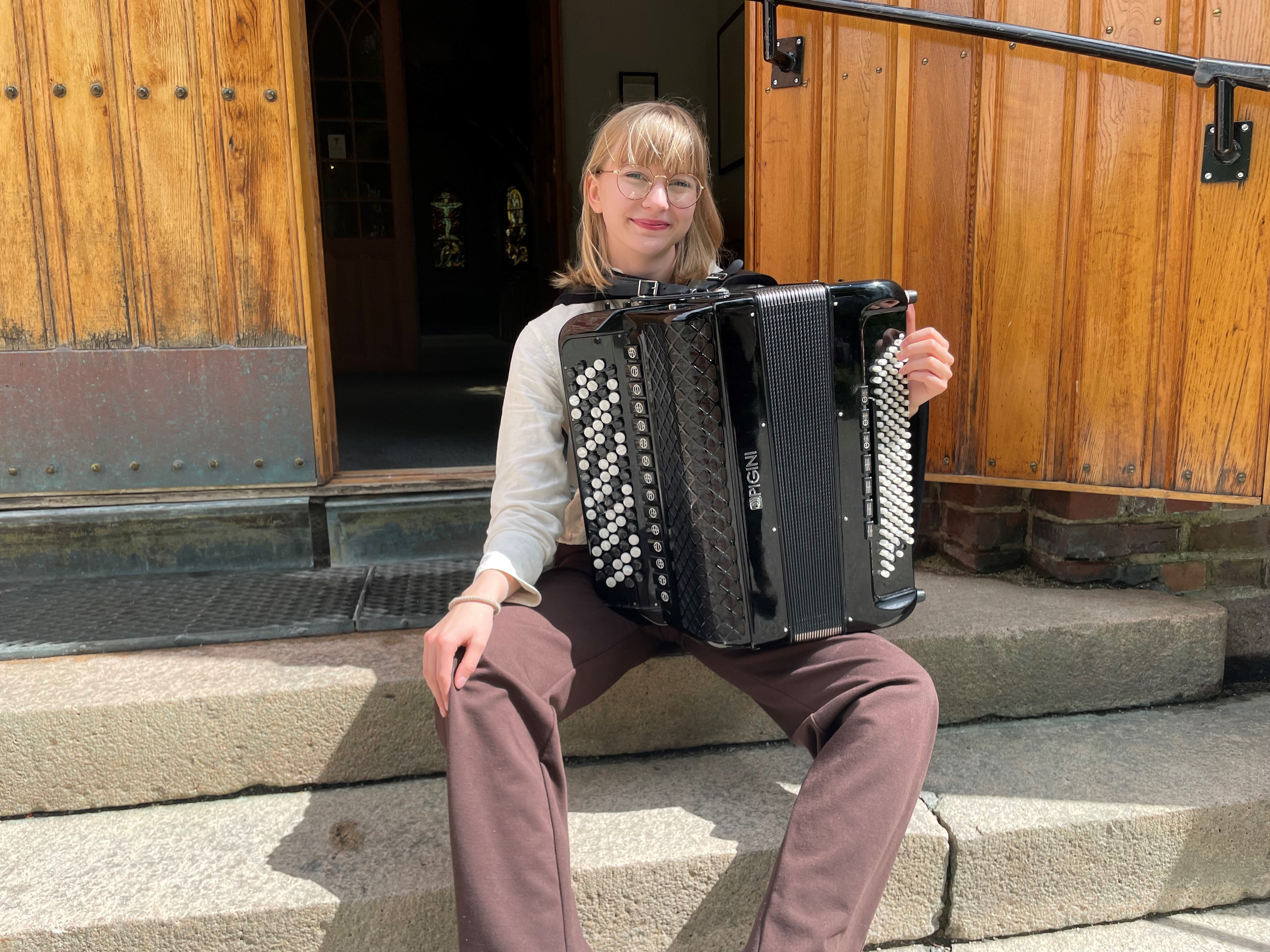 Vi har engasjert Mari Øen, en talentfull og dedikert ung musiker for å organisere og lede sommerkonsertene. Mari, som er 17 år gammel, har en solid bakgrunn i vårt barnekor, hvor hun har vært aktiv siden hun var seks år gammel. I tillegg til å være en erfaren korist, har Mari en ledende rolle som hjelpedirigent i Ås barne- og ungdomskantori. Hun er elev ved musikklinjen på Ski videregående skole, hvor hun nå går inn i sitt tredje år. Mari vil ikke bare bidra som utøvende artist med sitt trekkspill, men også organisere og samarbeide med andre unge frivillige musikere for å skape varierte og engasjerende konsertopplevelser. Foto: Linda Janson-Haddal