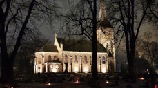 Asker kirke i flomlys med lys på gravene