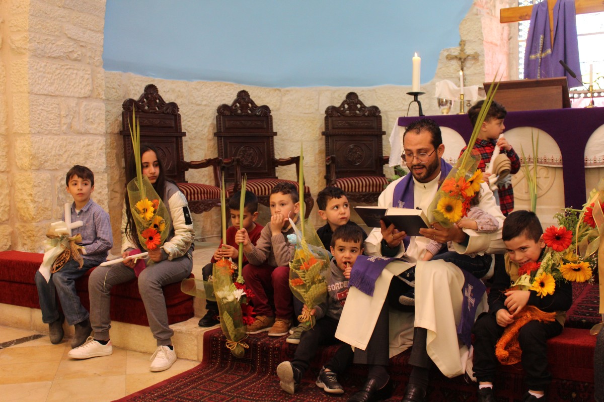 Sokneprest Ashraf Tannous, med barn i kirken i Beit Jala (fra deres hjemmeside)