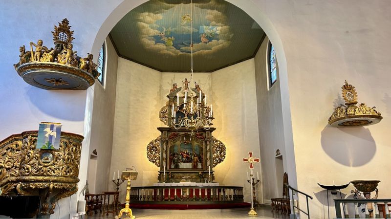 Prekestolen, altertavlen og døpefonten i Asker kirke.