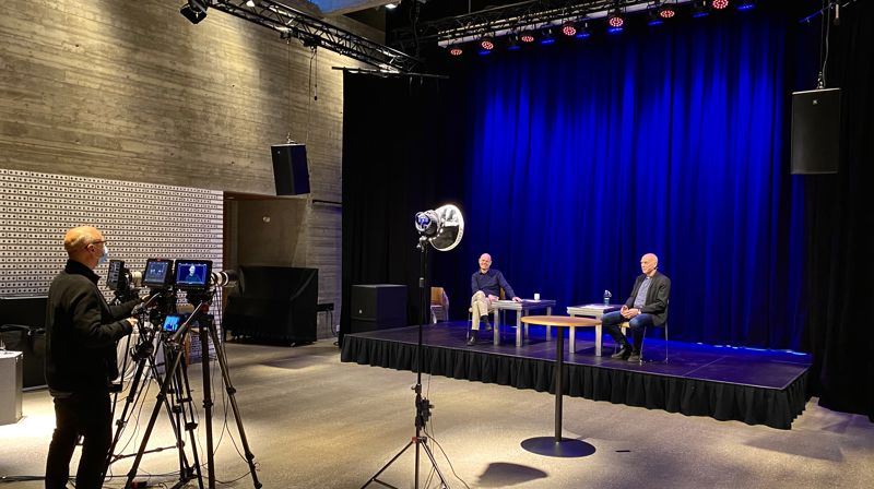 Avstand og samhold. På scenen kirkesjef John Grimsby og prost Tor Øystein Vaaland. Bak kamera: produsent Bo Mathisen, forskriftsmessig antrukket med munnbind. Foto: Jørgen Svartvasmo