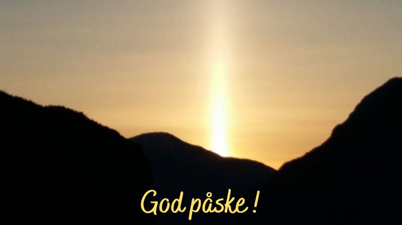 Solnedgang bak fjell med teksten "god påske!"