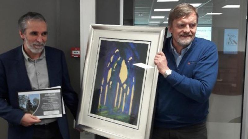 Kirkebyggsjef Arne Tveit mottar prisen av Harald Berge Breistein, leder for kommunalt råd for funksjonshemmede