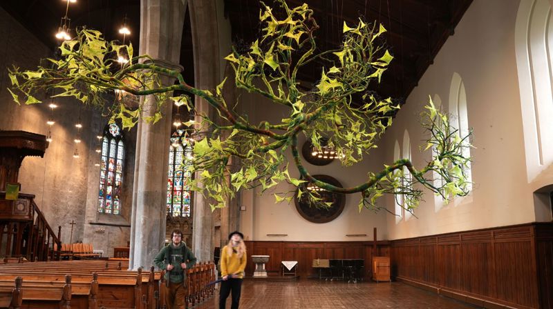 Linda Øgaards kunstinstallasjon svever i Bergen domkirke. Her er noen turister innom når kirken var åpen.