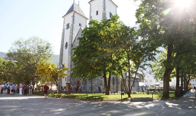 Mariakirken på bryggen i Bergen sett forfra i solskinn.