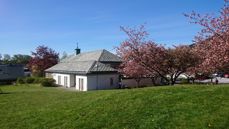 Fridalen kirke i vårsolen, sett fra plenen.