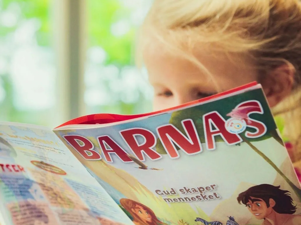 Jente som les i bladet «Barnas»