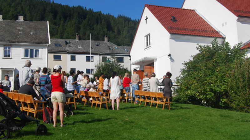 Forsamling på plenen utanfor Solheim kyrkje under gudsteneste i samband med Løvstakkdagane
