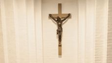 Krusifikset over døpefonten i Storetveit kirke fremstiller den lidende Kristus. Foto: Åse Solvi