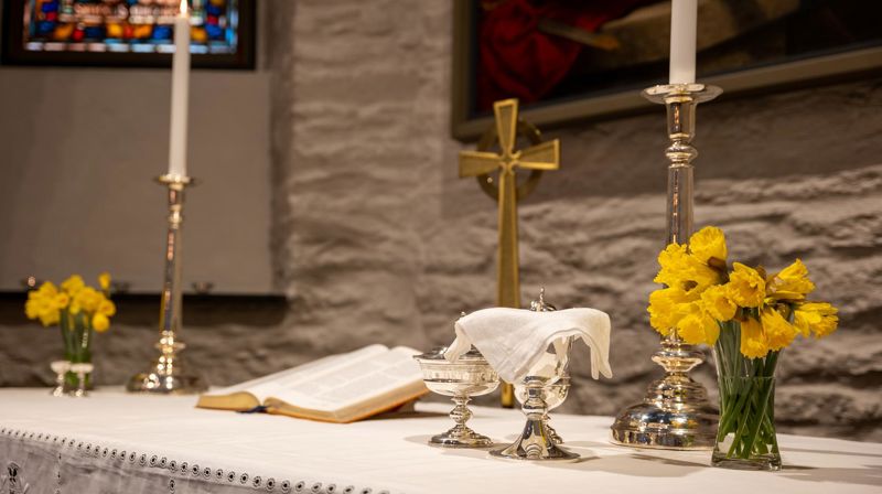 Bildet viser påskeliljer på et alter i en kirke. Foto: Terje Peersen