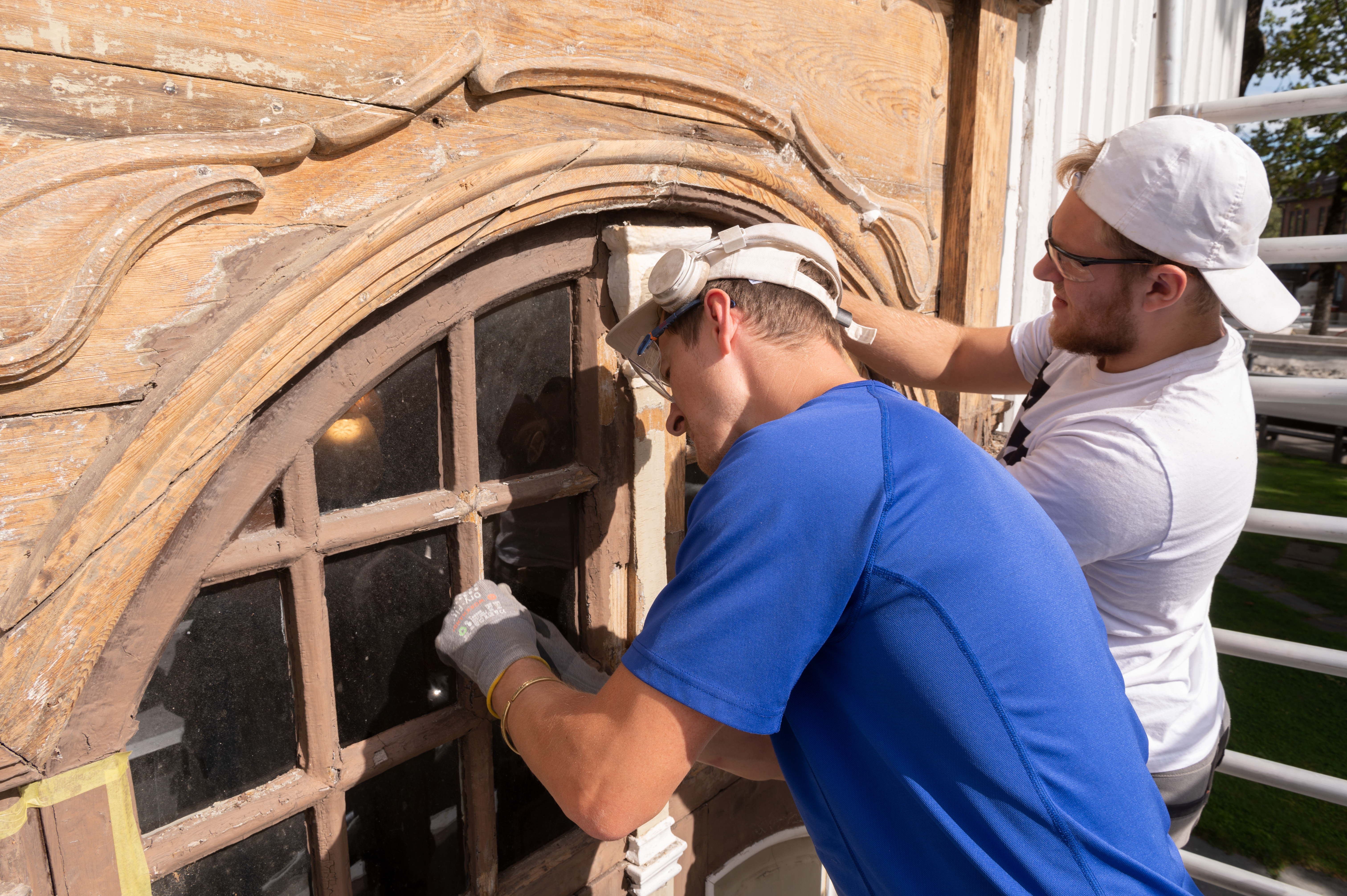 Dainius og Mantas i ferd med å skrape av malingen fra hovedportalen.