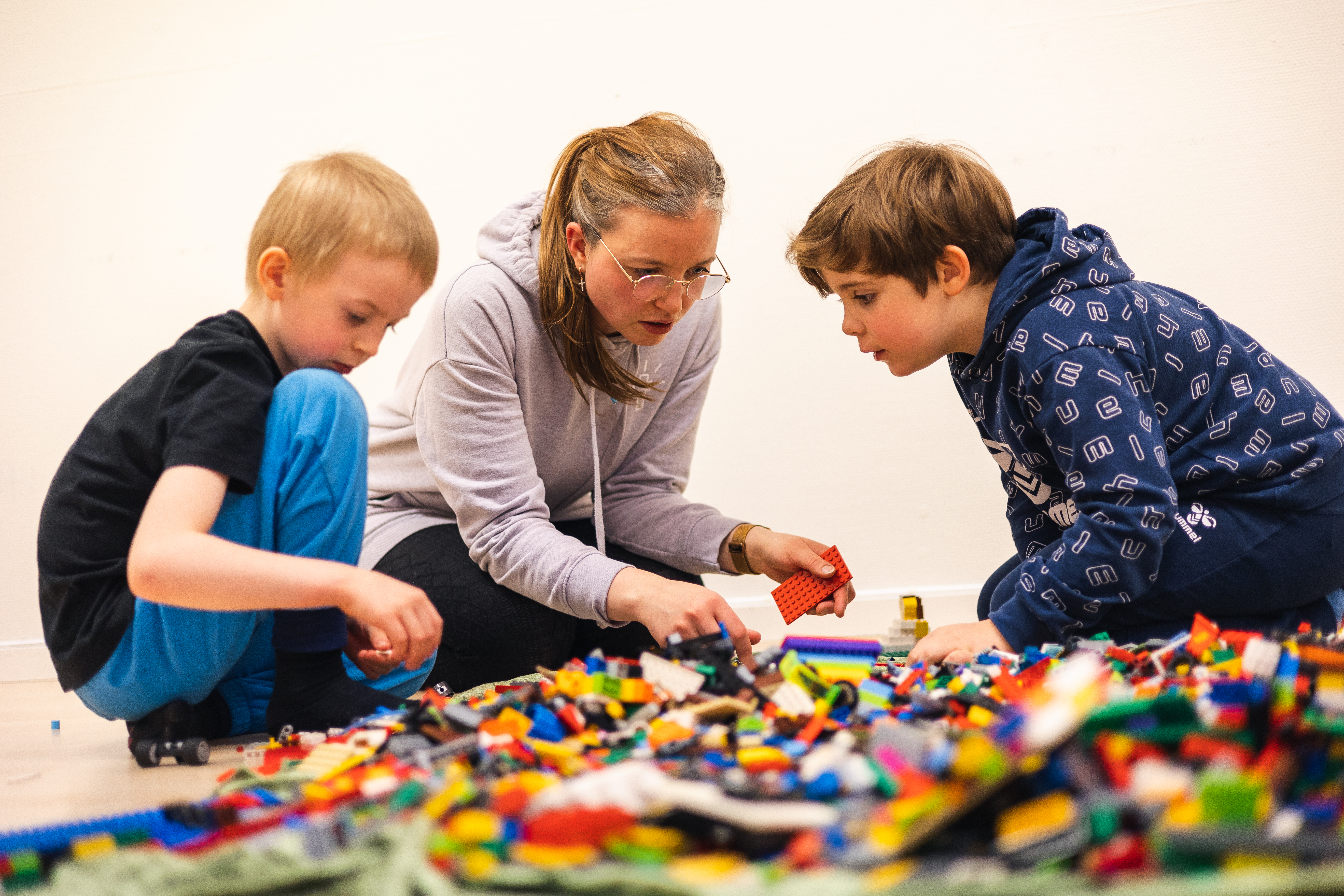Kyrkjelydspedagog og barn på legoklubb. Foto: Den norske kirke.