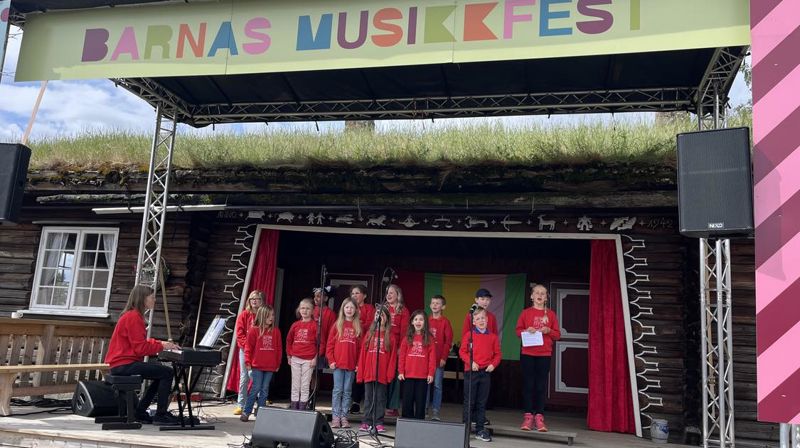 Brandbu Barnekantori og Kormix deltok under den store "Barnas Musikkfest" på Hadeland Folkemuseum i juni 2024. Her er de under fremføringen sammen med korleder Marit Wesenberg (foto: Anne-May Lervik).