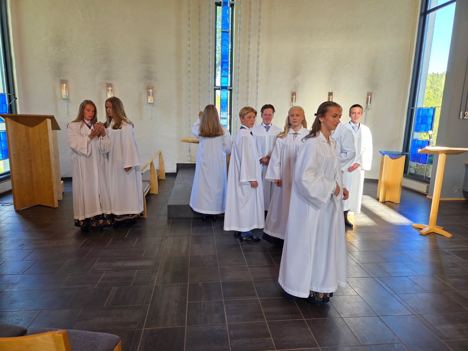 Det er prøving av kapper og fotografering av konfirmantene like før konfirmasjonen. Her ser vi konfirmantene gjøre seg klare for fotografering i Grymyr kirke, våren 2026. Foto: Jan Myrvold. 