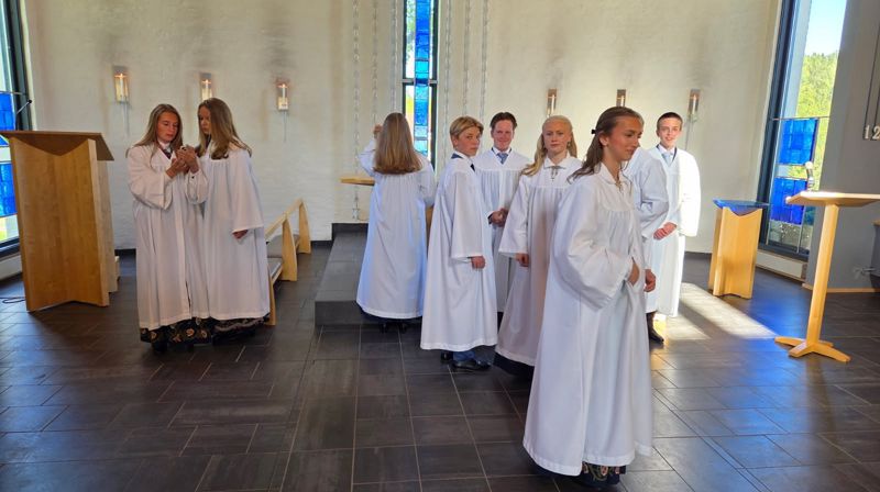Det er prøving av kapper og fotografering av konfirmantene like før konfirmasjonen. Her ser vi konfirmantene gjøre seg klare for fotografering i Grymyr kirke, våren 2026. Foto: Jan Myrvold.