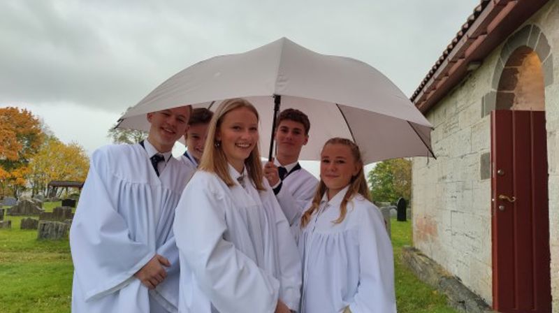 Ved konfirmasjon i kirka får du noe mer, noe ekstra. Du lærer om kristen tro og tradisjon. Fra konfirmasjon i Nikolaikirken i 2021 med regn og felles paraply! (Foto: Daniel Håkegård).