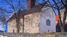 Mariakirken med hvitkalket østvegg og stillas på vestveggen. Nå er østveggen hvitkalket og stillaset satt opp mot sør for å ta siste veggen. I høst vil all sement i fugene være fjernet og erstattet med kalk og kirken være hvitkalket på nytt (foto: Morten Stige).