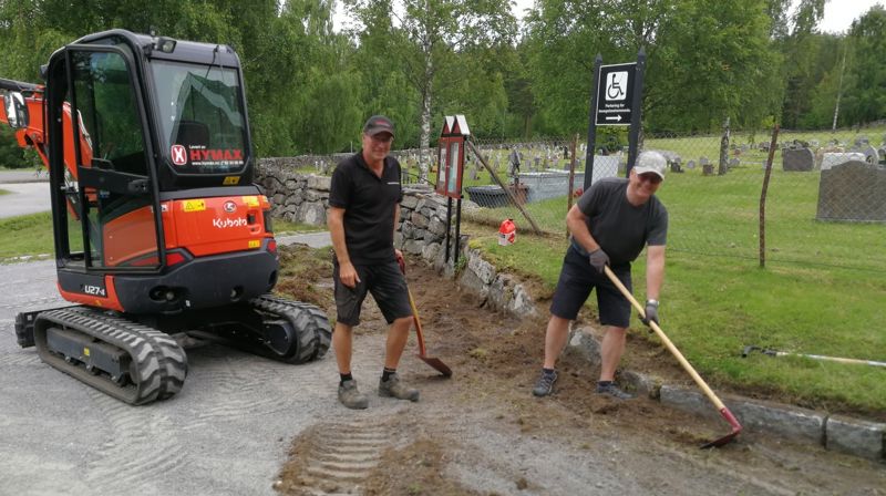 Kirketjenerne Terje Hognestad og Jan Myrvold graver frem igjen kantestein utenfor Moen kirke og gravplass. Et eksempel på sommeroppgaver ute (foto: Knut Bøe).