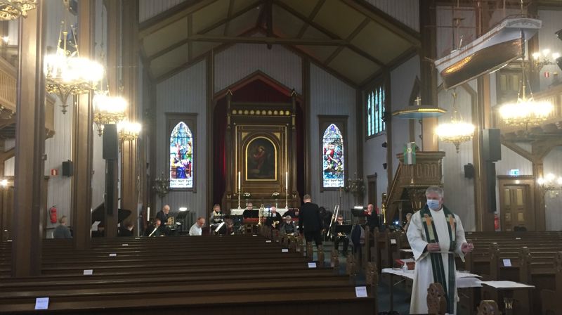 Sogneprest Hjalmar Bjerga forrettet nattverd under kirkevandringen. I bakgrunnen messingblåsegruppe som gjestet menigheten denne søndagen.