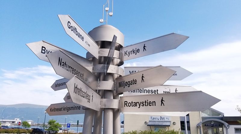 "Peikepinnen" som viser ulike opplevingar i Hareid. Det var gruppa Hafest som fekk reist "Peikepinnen" ved terminalen i sentrum av Hareid. Foto: Hareid sokn