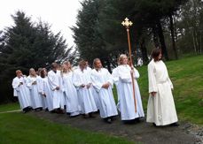 Menighetspedagog Ingunn Bergsager Våge leder prosesjonen inn til konfirmasjon i Rossabø kirke.