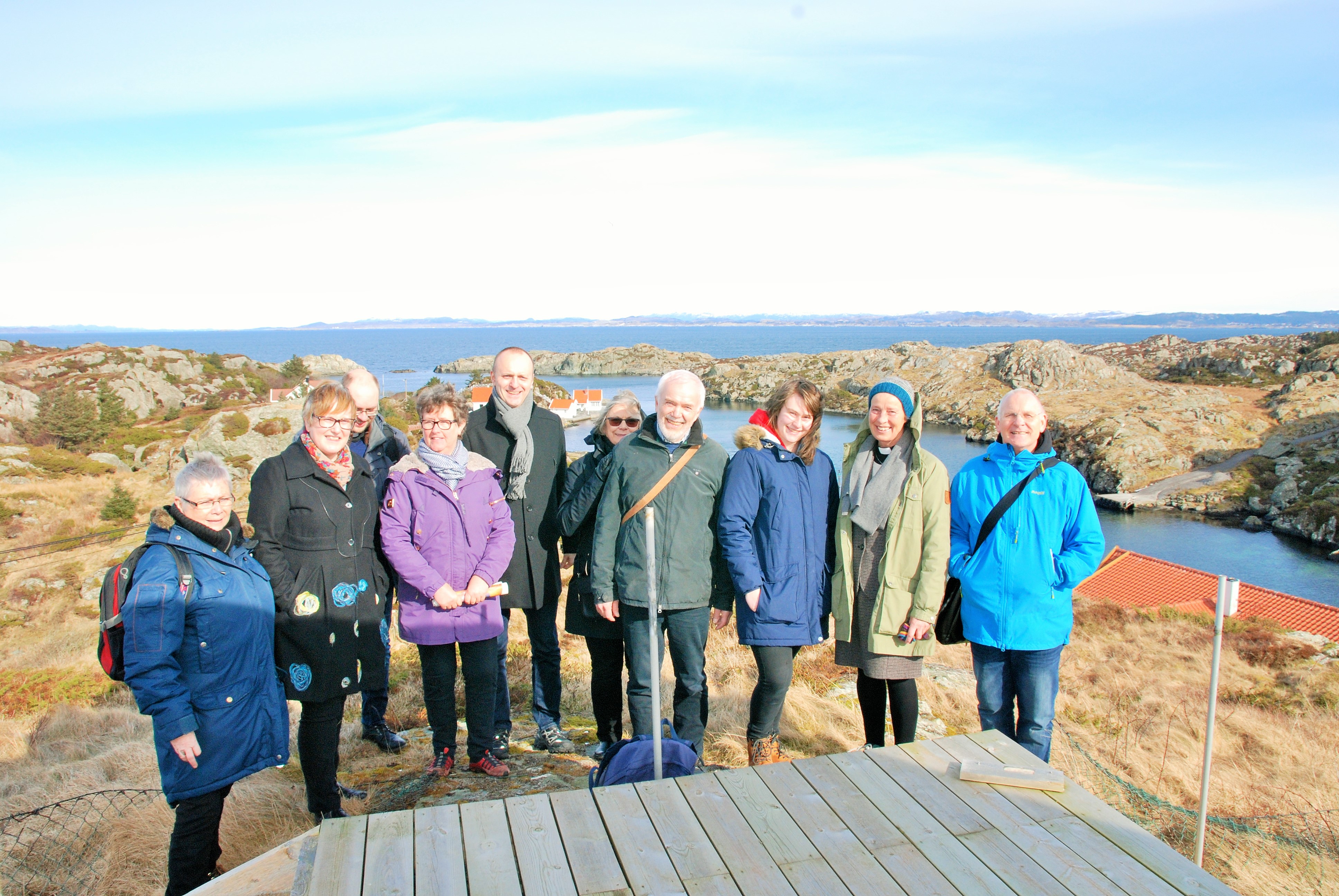 Fungerende biskop Anne Lise med følge samlet etter "Bønn for soknet" på toppen av Røvær, med god utsikt inn til byen.