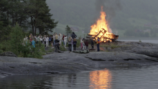 Bilde frå sommarleir 2022, båltenning på svaberg med deltakarar rundt bålet. Foto Karoline Thyri.