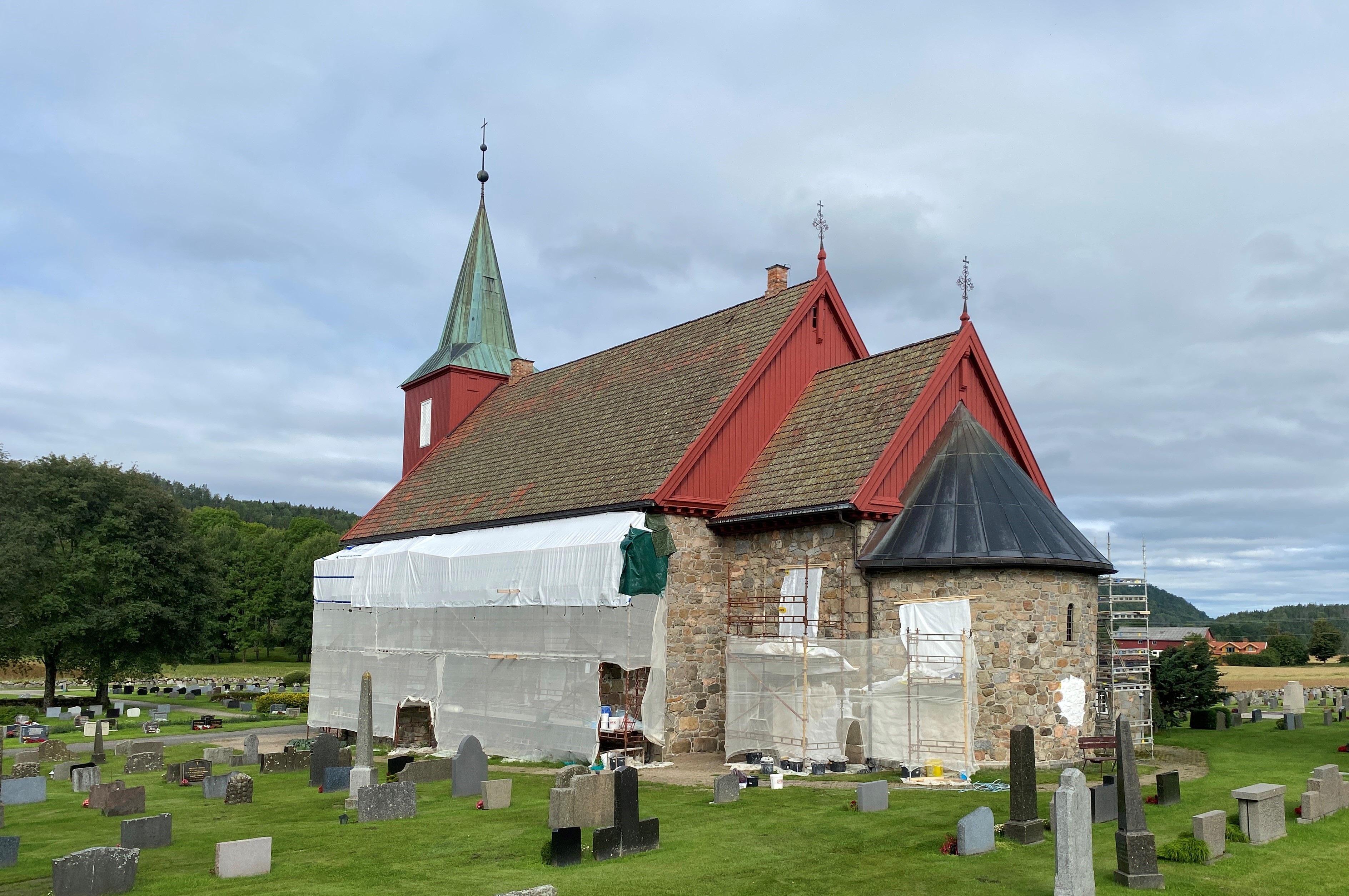 Sørveggen på Hedrum kirke er for tiden tildekket på grunn av vedlikeholdsarbeidet.