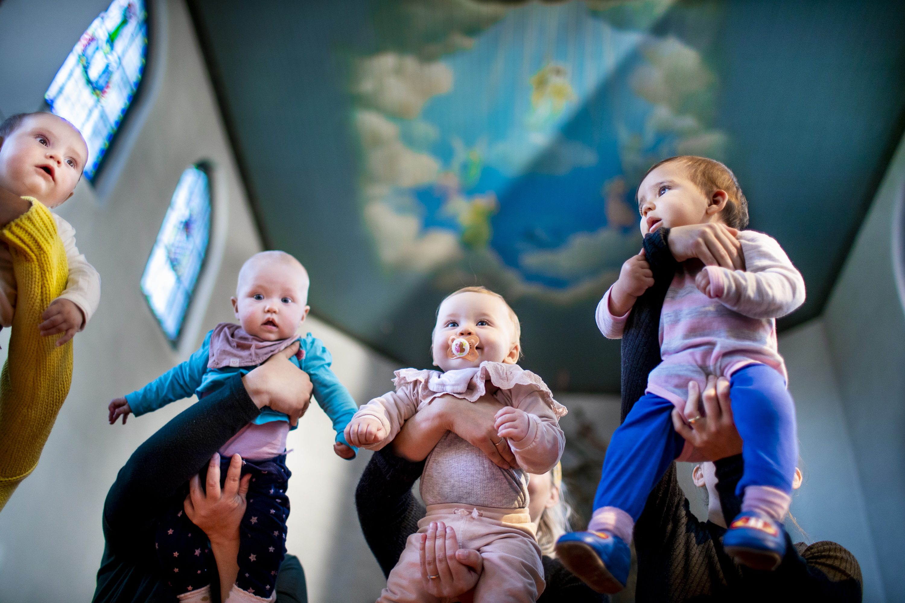 Vi ser fire babyer som løftes opp